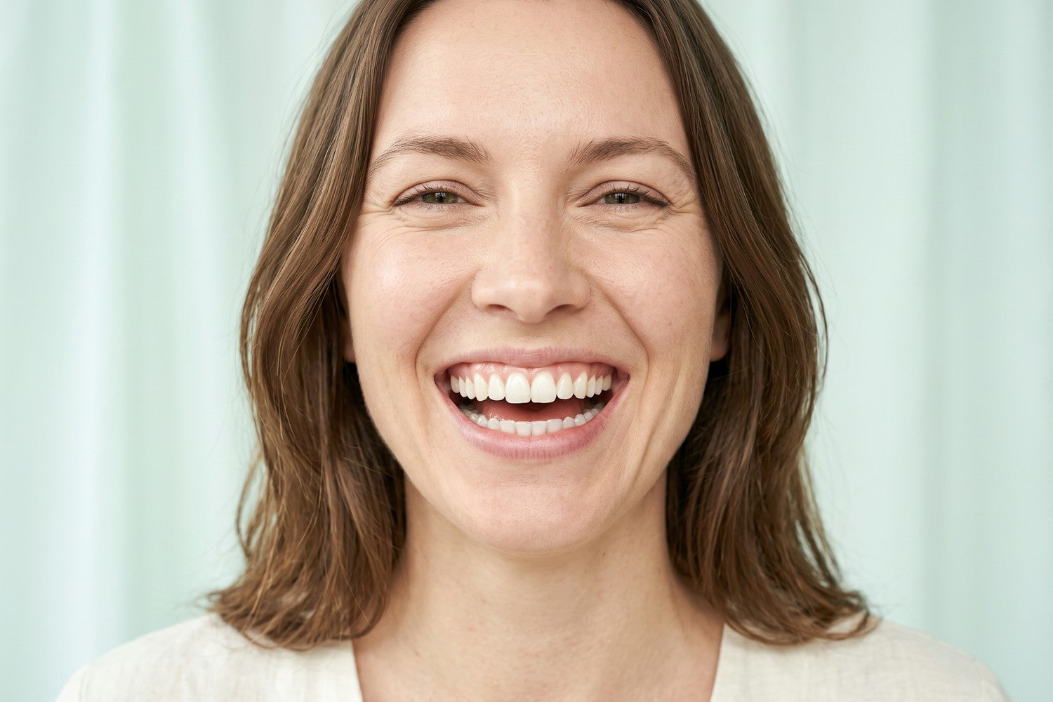 A woman laughing with a bright natural smile